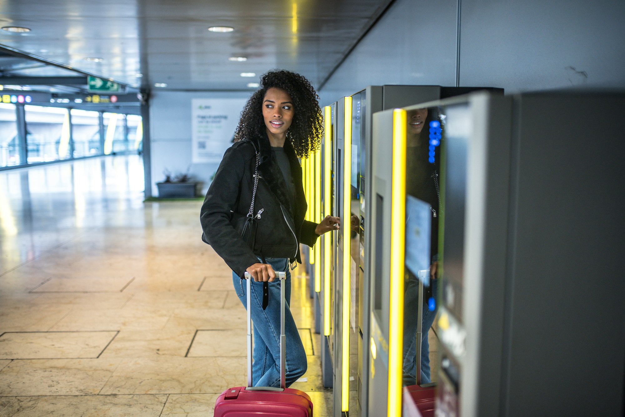 black Woman paying in the parking Machine in the airport with a