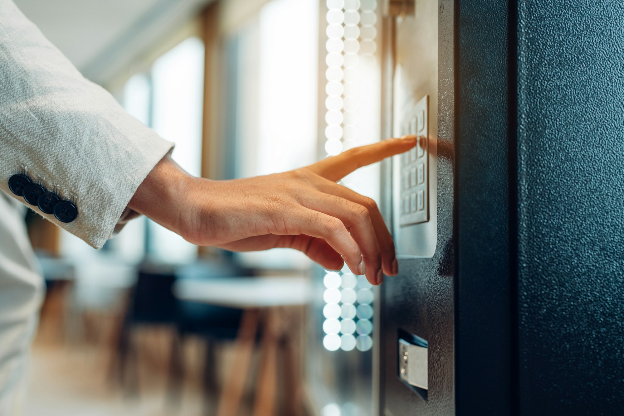 woman's finger pushing number button on keyboard of snack vending machine.